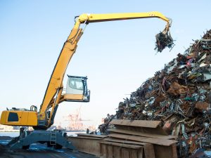 excavator working a steel pile at metal recycling facility