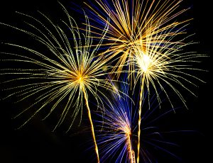 A firework show with bright flashes of light against a night sky.
