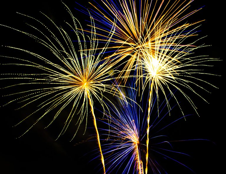 A firework show with bright flashes of light against a night sky.